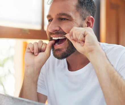 A man flossing his teeth