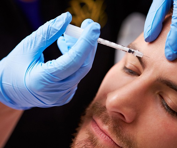 a man receiving BOTOX injections in his forehead