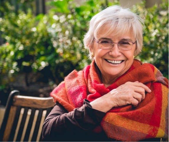 Smiling senior woman wearing shawl outdoors