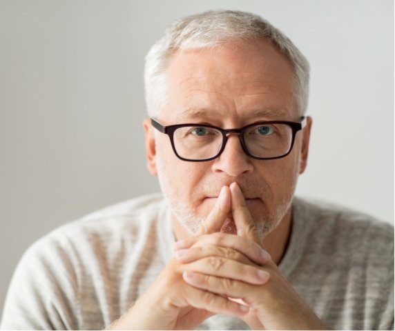 Senior man with glasses looking contemplative