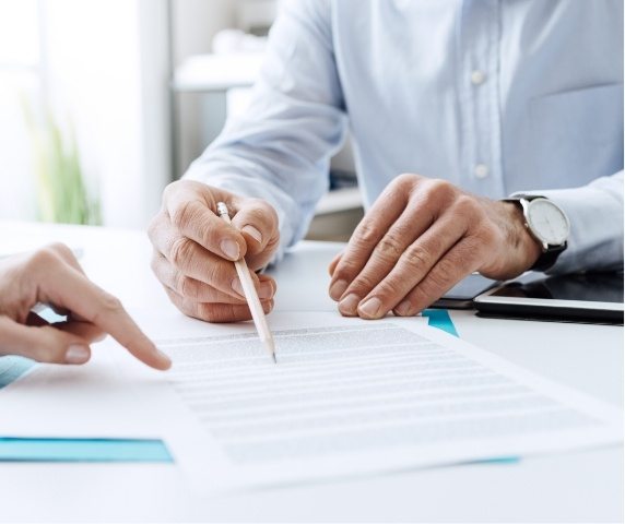 Man reading through paperwork on table