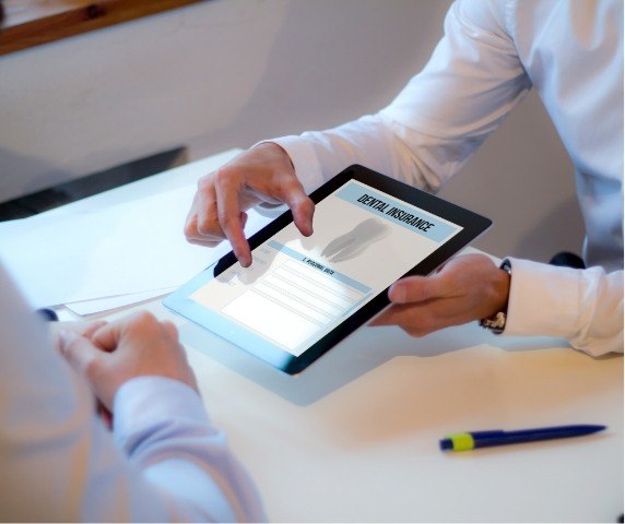 Two people looking at dental insurance information on a tablet