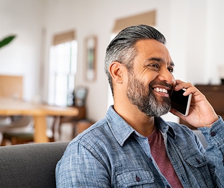 Man smiling while talking on phone