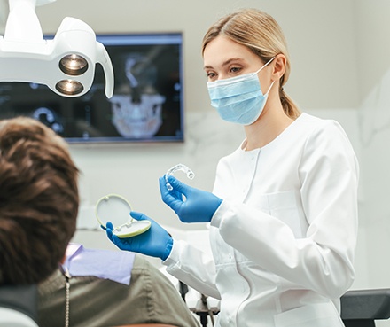 Dentist showing patient clear aligner in treatment room