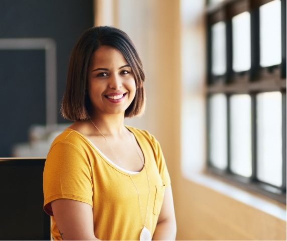 Smiling young woman in yellow shirt