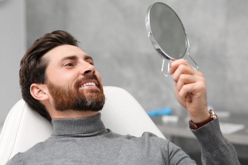 Patient smiling after getting dental crowns