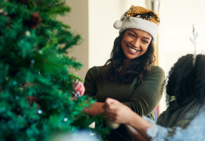 woman and child decorating a Christmas tree