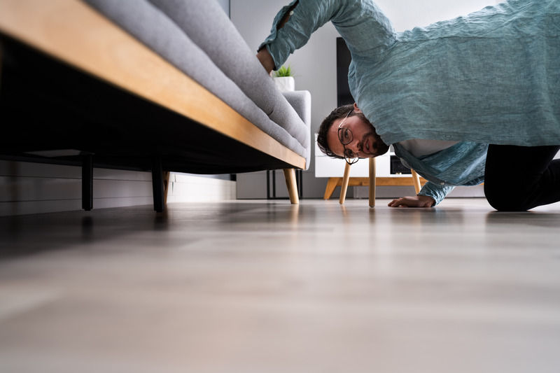 Patient looking under a couch for Invisalign aligner